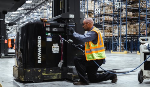 Technician watering a lift truck battery